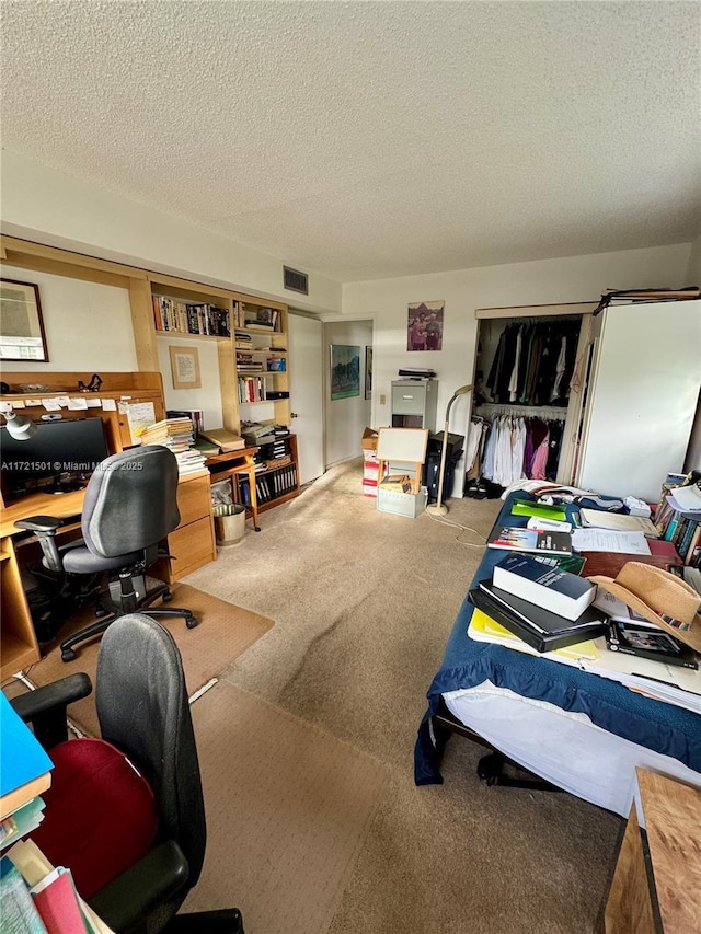 carpeted office space featuring a textured ceiling