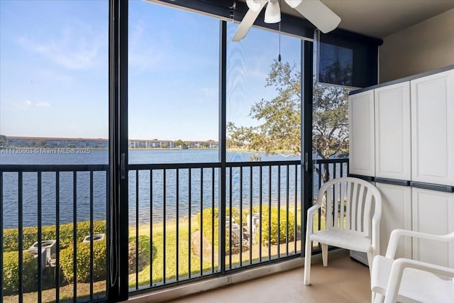 unfurnished sunroom featuring ceiling fan, a water view, and a wealth of natural light