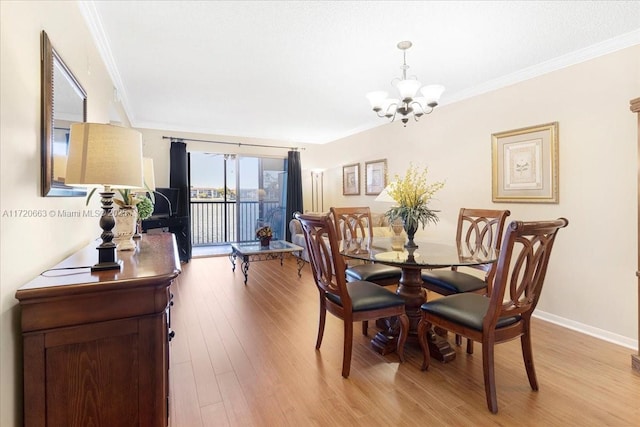 dining space featuring a chandelier, light hardwood / wood-style floors, and ornamental molding