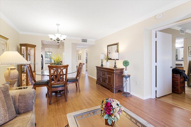 living room with crown molding, a chandelier, a textured ceiling, and hardwood / wood-style flooring