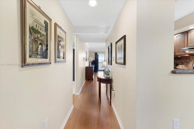 hallway with light hardwood / wood-style flooring