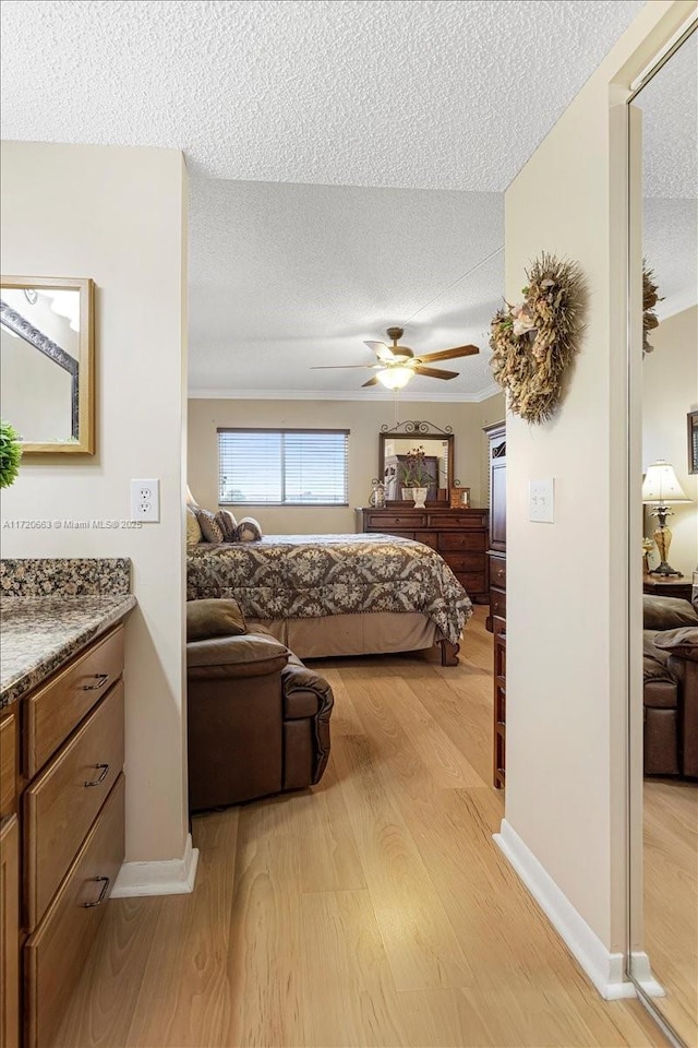 bedroom featuring a textured ceiling, light hardwood / wood-style floors, and ceiling fan