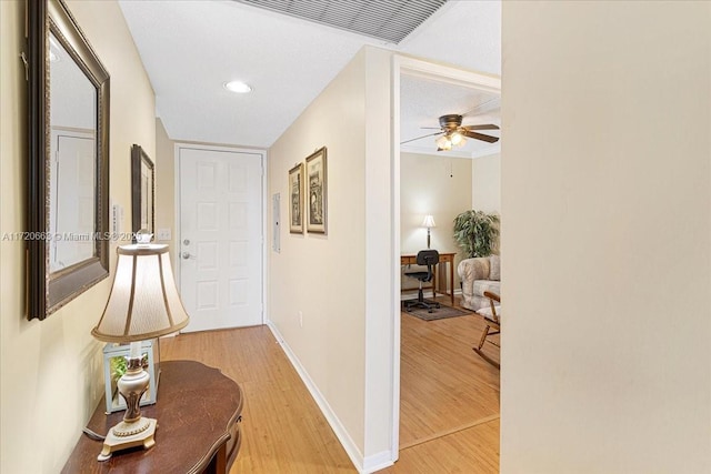 hall with a textured ceiling and hardwood / wood-style flooring