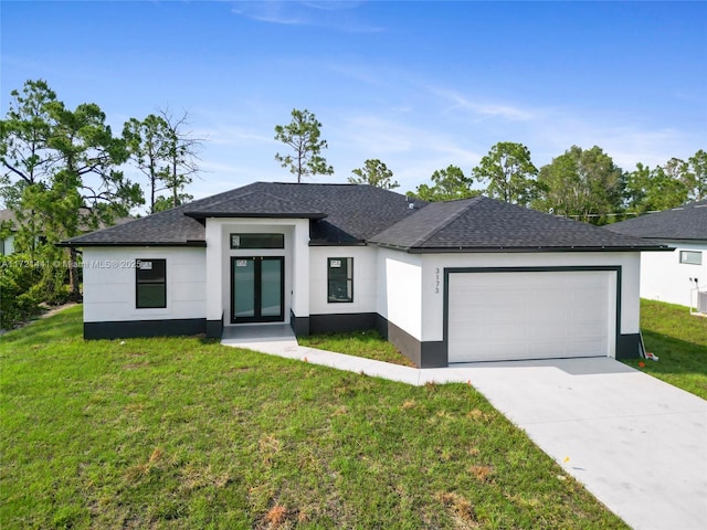 view of front of home with a front yard and a garage