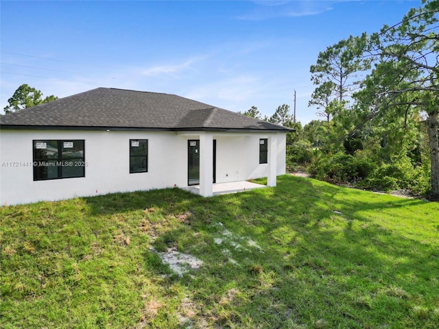 rear view of property featuring a lawn and a patio