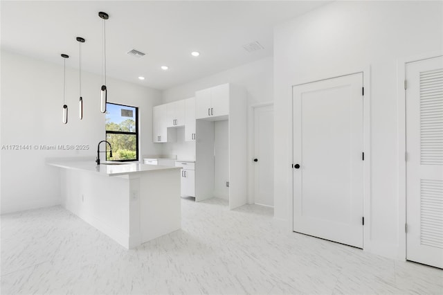 kitchen with kitchen peninsula, decorative light fixtures, white cabinetry, and sink