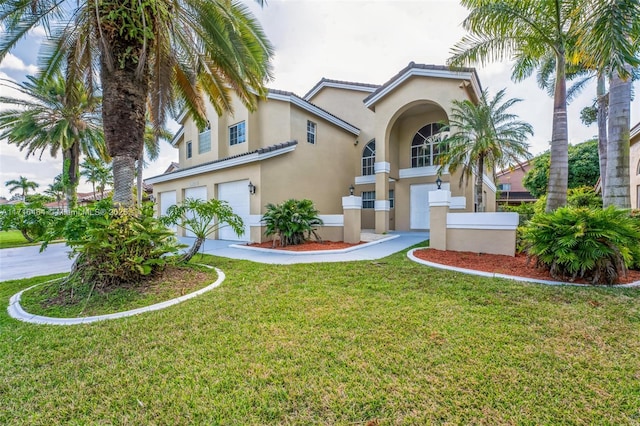 mediterranean / spanish house with a front lawn and a garage