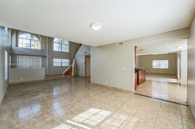 unfurnished room with a textured ceiling and light tile patterned floors