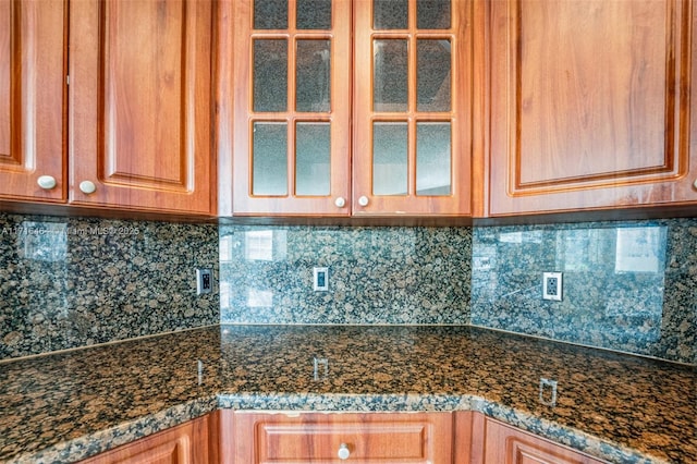 kitchen featuring dark stone counters and tasteful backsplash