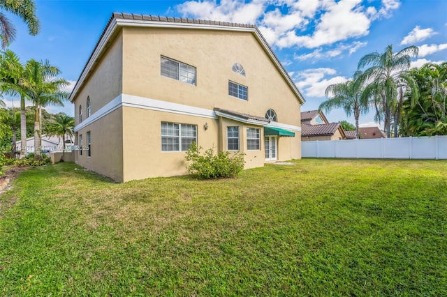 back of property featuring a lawn