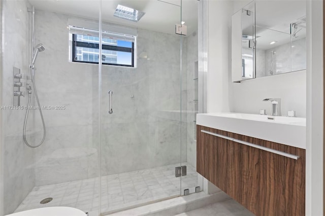 bathroom featuring vanity, a skylight, and an enclosed shower