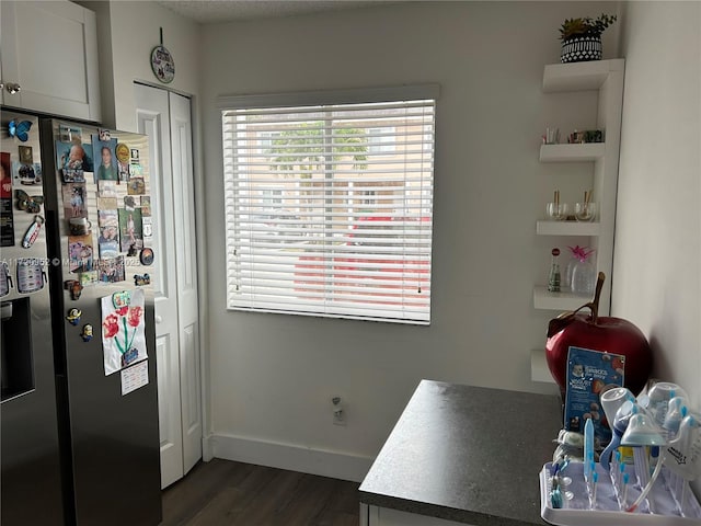 interior space featuring white cabinets, dark hardwood / wood-style flooring, and stainless steel refrigerator with ice dispenser