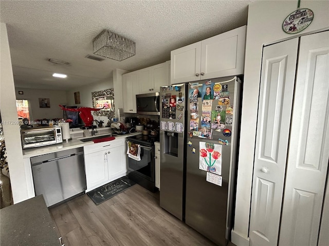 kitchen with sink, white cabinets, stainless steel appliances, and a textured ceiling