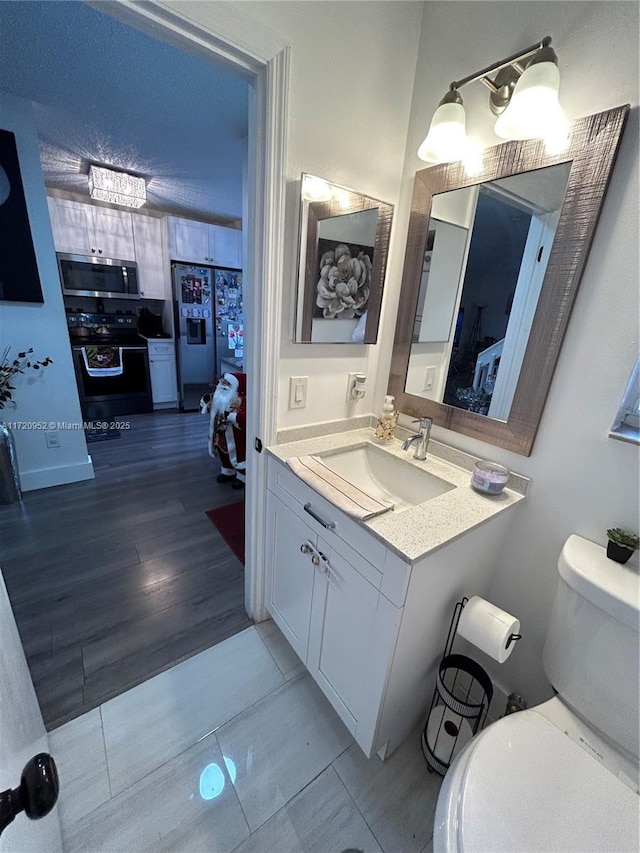 bathroom featuring hardwood / wood-style floors, vanity, and toilet