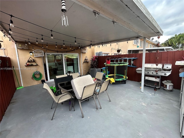 view of patio featuring central AC unit, a grill, and a trampoline