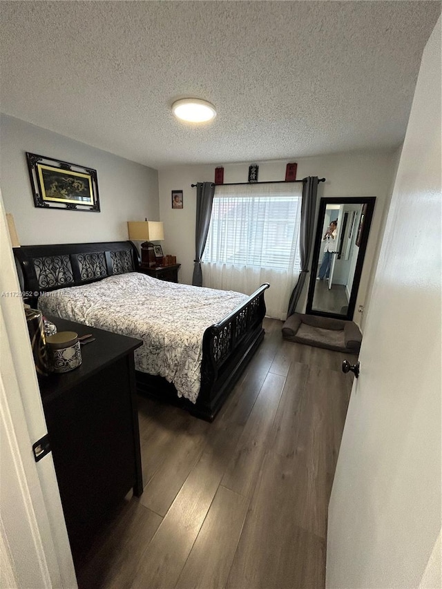 bedroom featuring dark hardwood / wood-style floors and a textured ceiling