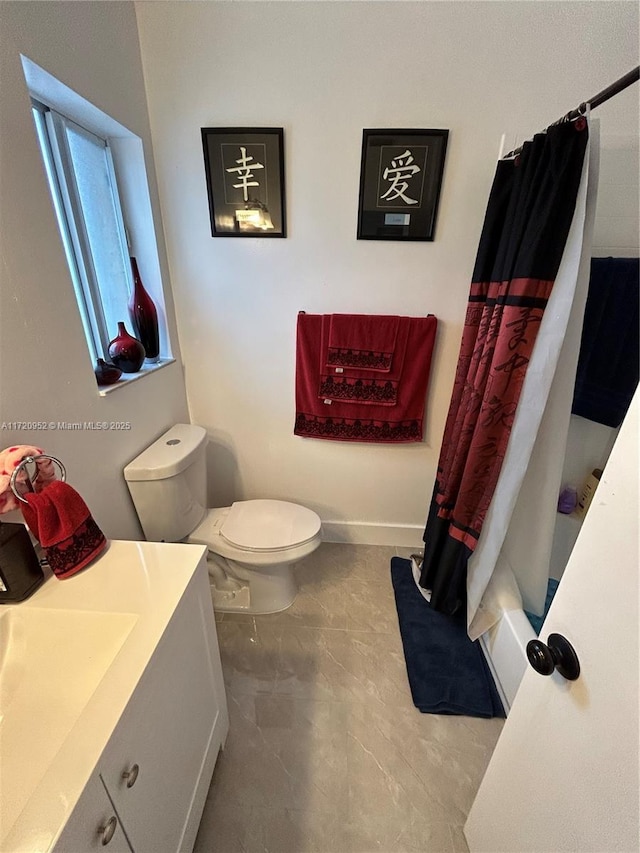 full bathroom with shower / tub combo, vanity, and toilet