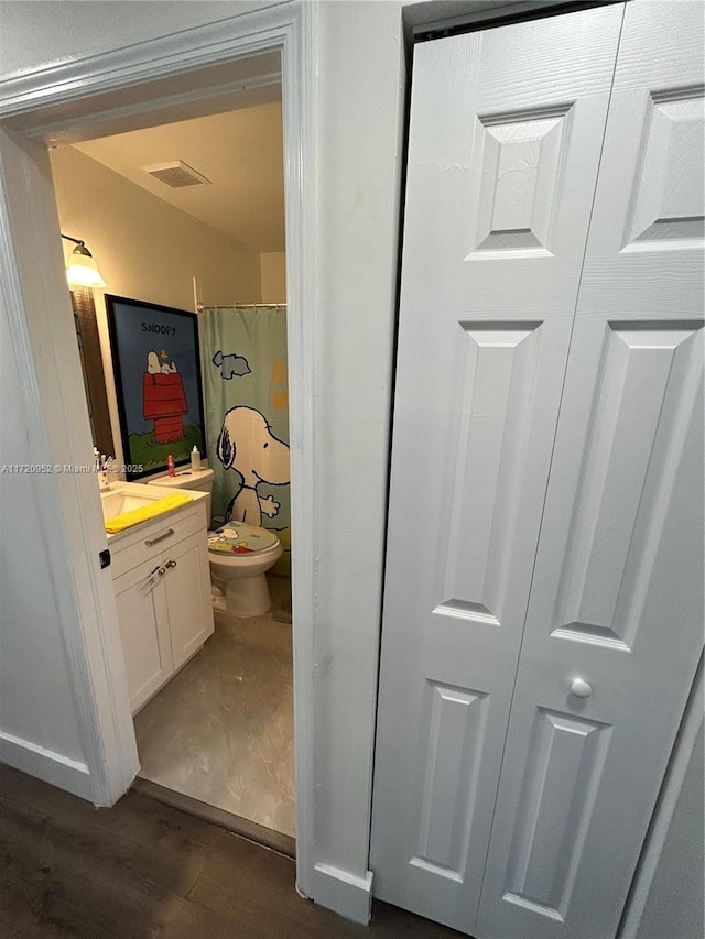 bathroom featuring wood-type flooring, vanity, toilet, and a shower with curtain