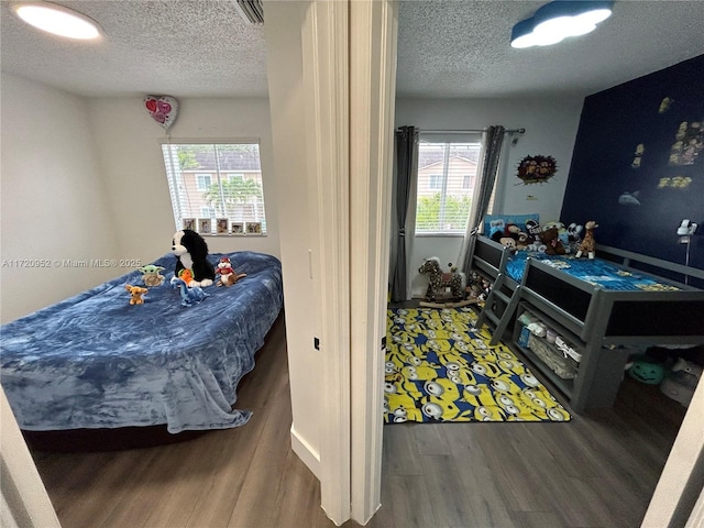 bedroom with a textured ceiling and dark wood-type flooring