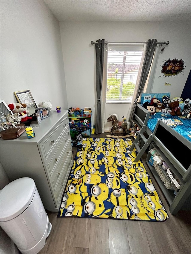 bedroom with wood-type flooring and a textured ceiling