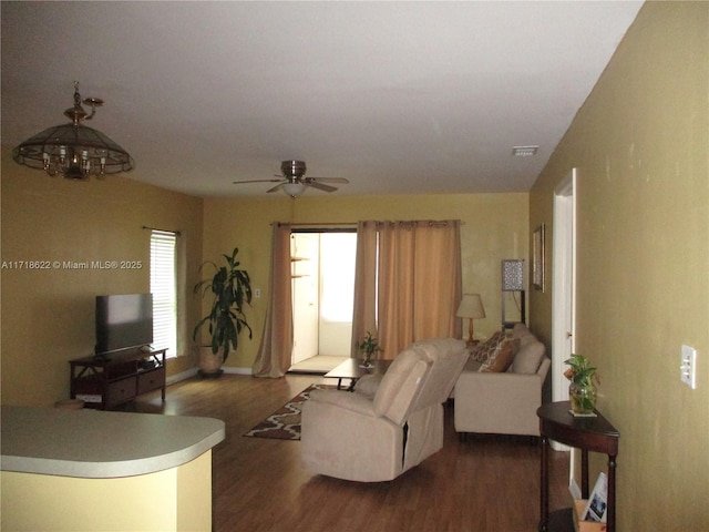 living room with ceiling fan and dark hardwood / wood-style flooring