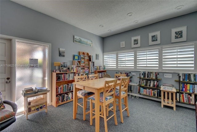 dining space with carpet and a textured ceiling