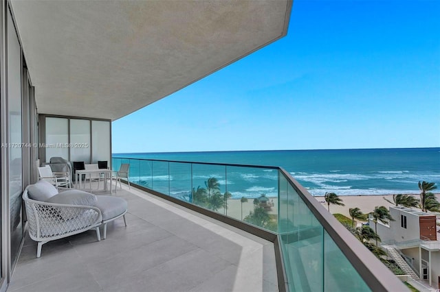 balcony featuring a beach view and a water view