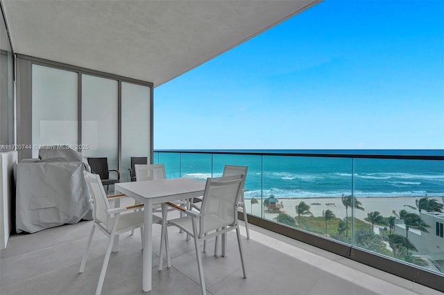 balcony with a water view and a view of the beach