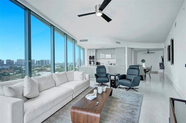 living room with ceiling fan, expansive windows, and sink