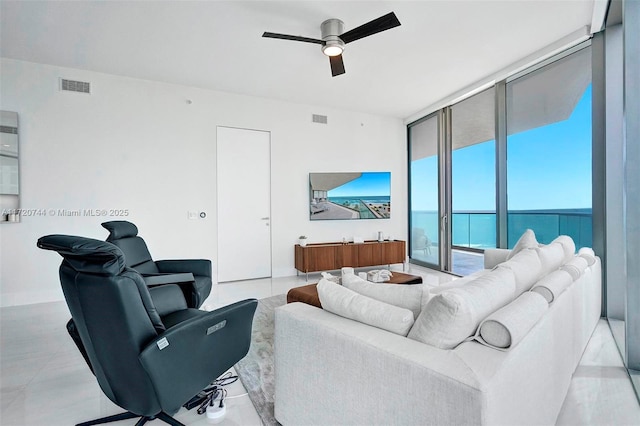 living room featuring ceiling fan and expansive windows