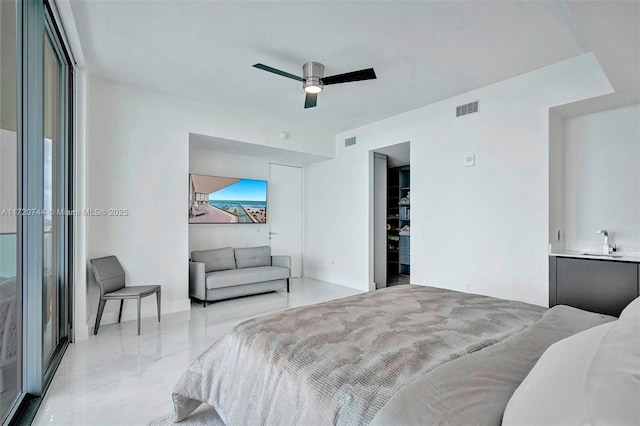 bedroom featuring ceiling fan and sink