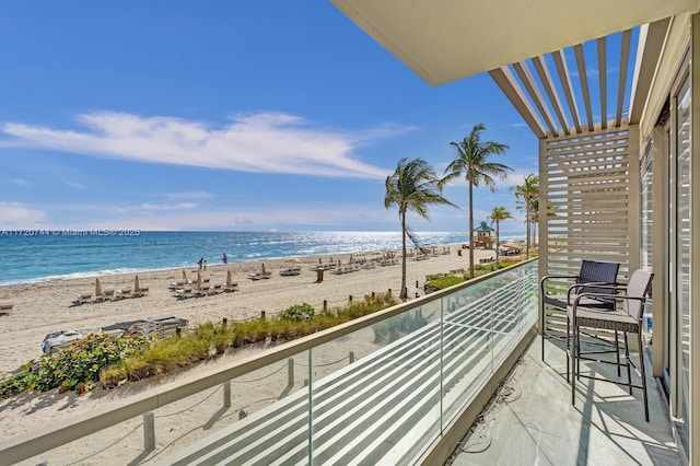 balcony featuring a view of the beach and a water view