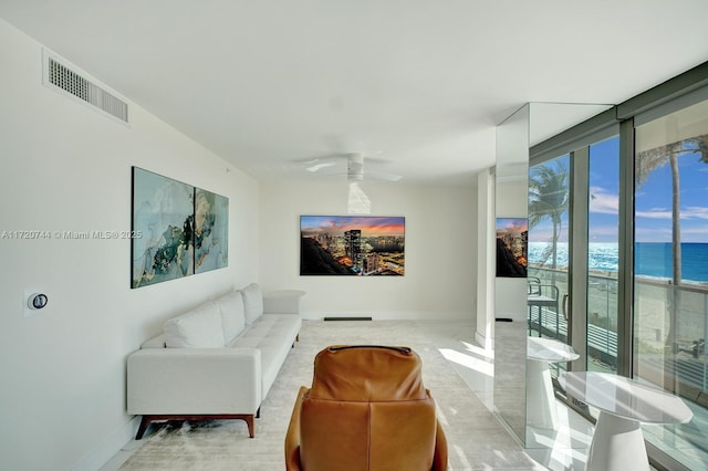 living room featuring ceiling fan and a water view