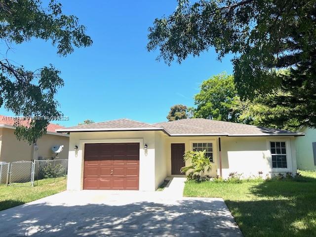 1574 NW 7th Ln, Pompano Beach, FL 33060 - single story home with an attached garage, driveway, and stucco siding