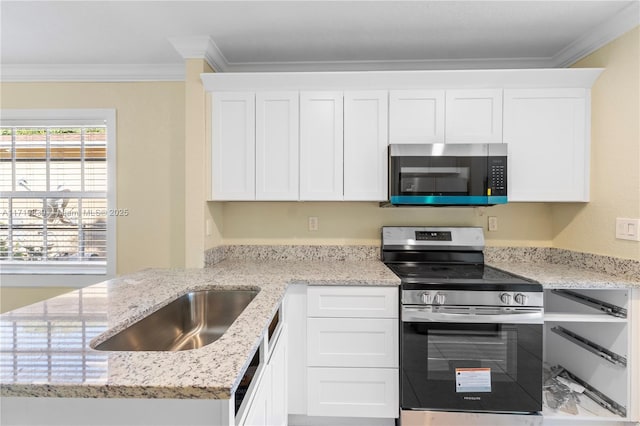 kitchen featuring white cabinets, ornamental molding, and stainless steel appliances