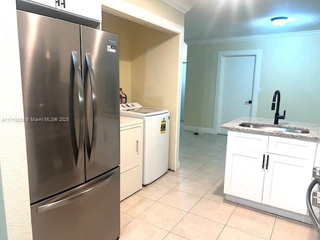 1574 NW 7th Ln, Pompano Beach, FL 33060 - kitchen with freestanding refrigerator, separate washer and dryer, ornamental molding, white cabinets, and light tile patterned flooring