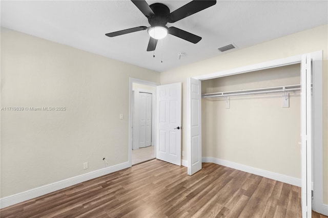 unfurnished bedroom featuring ceiling fan, wood-type flooring, and a closet