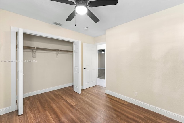 unfurnished bedroom featuring dark hardwood / wood-style flooring, a closet, and ceiling fan