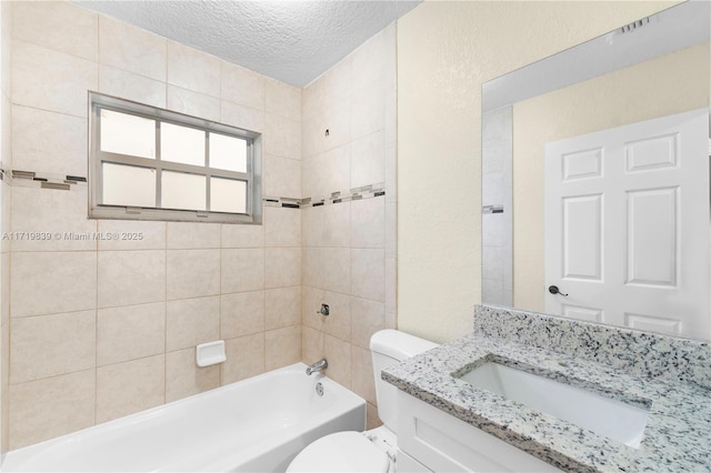 full bathroom featuring toilet, vanity, a textured ceiling, and tiled shower / bath