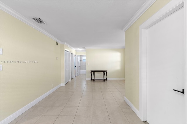 hall with ornamental molding and light tile patterned floors