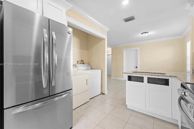 kitchen with crown molding, washing machine and dryer, appliances with stainless steel finishes, light stone counters, and white cabinetry