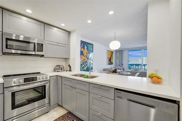 kitchen featuring gray cabinetry, kitchen peninsula, sink, and appliances with stainless steel finishes