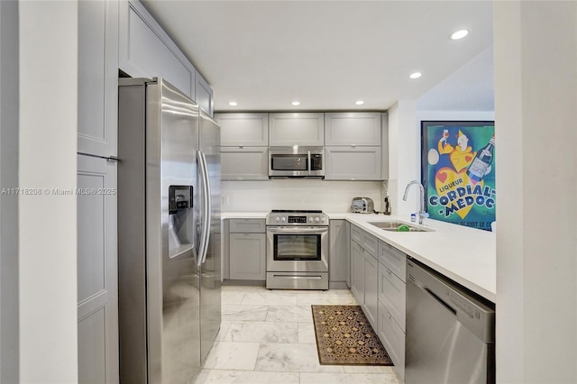 kitchen featuring gray cabinets, sink, and stainless steel appliances