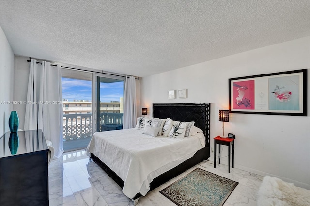 bedroom with access to exterior, a textured ceiling, and a wall of windows