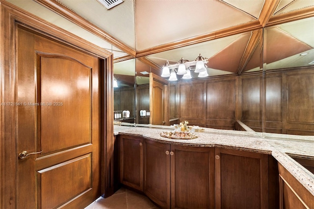 bathroom featuring tile patterned flooring, vanity, and wooden walls