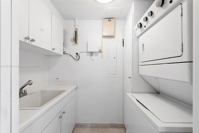 washroom featuring electric panel, cabinets, sink, and stacked washing maching and dryer