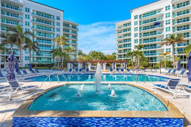 view of swimming pool with pool water feature and a patio area