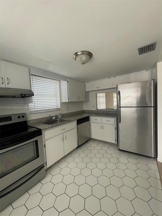 kitchen featuring stainless steel appliances, white cabinetry, and sink