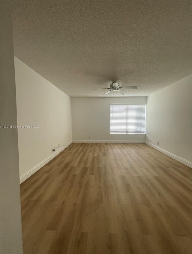 empty room featuring hardwood / wood-style floors, a textured ceiling, and ceiling fan