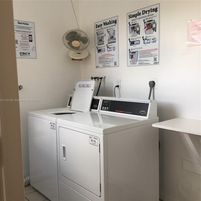 laundry area featuring light tile patterned floors and washer and clothes dryer